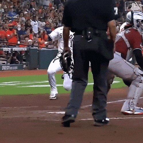 a baseball game is being played in front of a crowd with a sign that says ' stadium ' on it