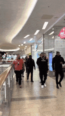 a group of people walking in a mall with a tiktok watermark on the bottom right