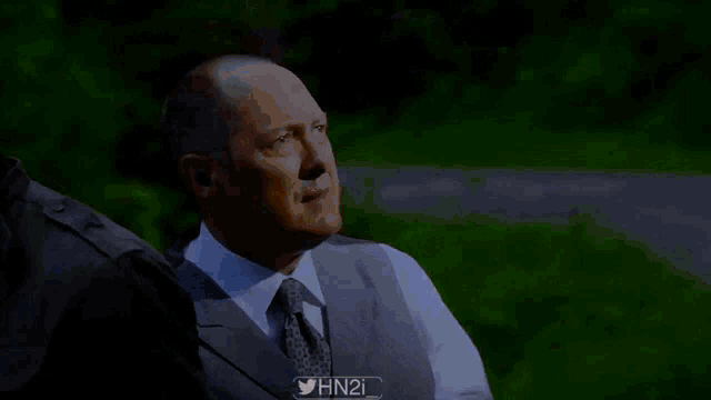 a man in a suit and tie is covering his face with a hat and the twitter hashtag #hn2i
