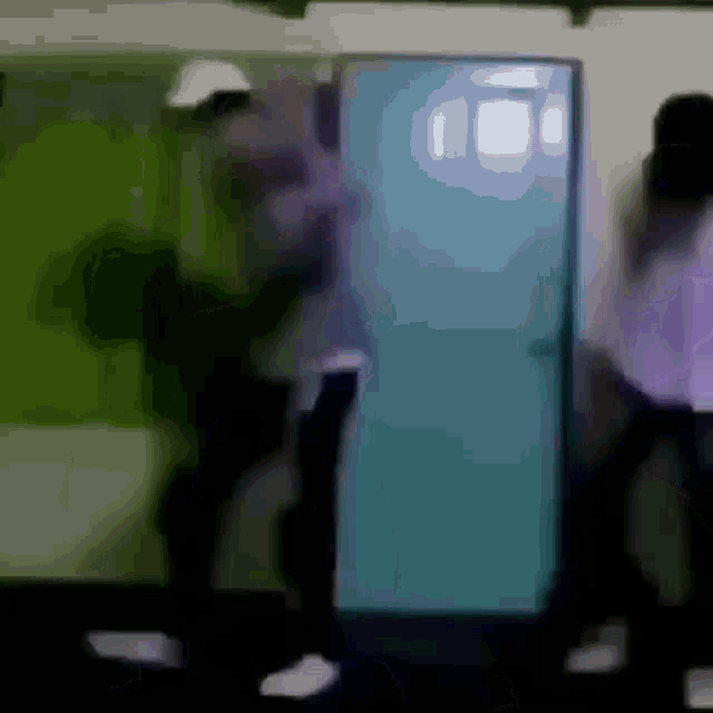 a blurry picture of a person standing next to a blue door .