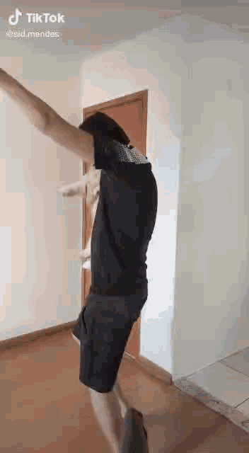 a man is jumping in the air with his arms outstretched in a room .