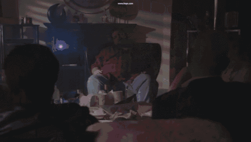 two men are sitting on a couch with their hands in the air