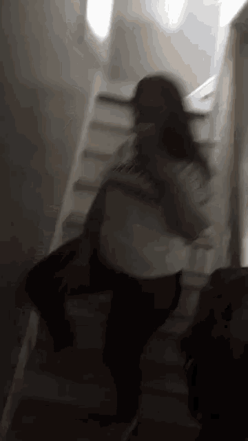 a blurry picture of a woman walking down stairs