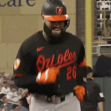 a baseball player for the orioles is wearing orange gloves and a helmet .