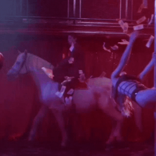 a man is riding a horse with money falling from the ceiling