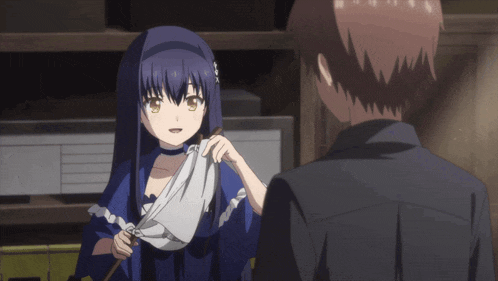 a girl in a blue dress is holding a white cloth and talking to a man