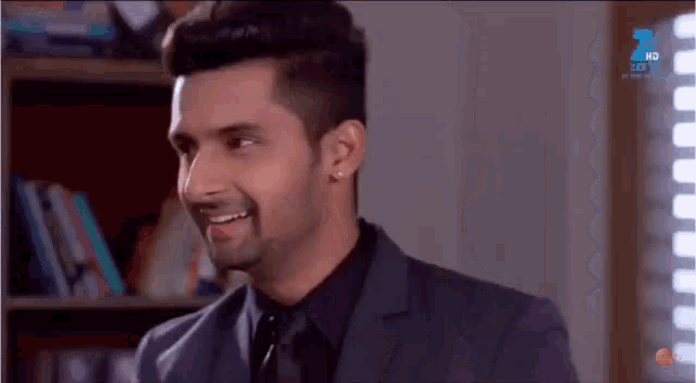 a man in a suit and tie is smiling and sticking his tongue out .