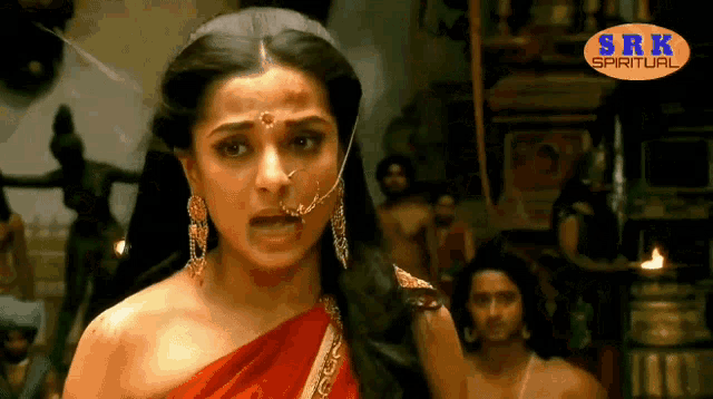 a woman in a red dress with a srk spiritual logo on the bottom