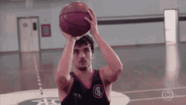 a man is holding a basketball over his head while playing basketball on a court .