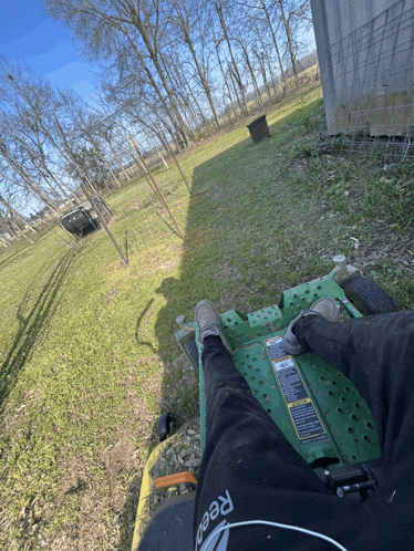 a person riding a lawn mower wearing a reebok shirt