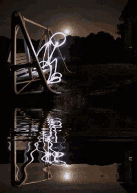 a light painting of a person on a swing at night
