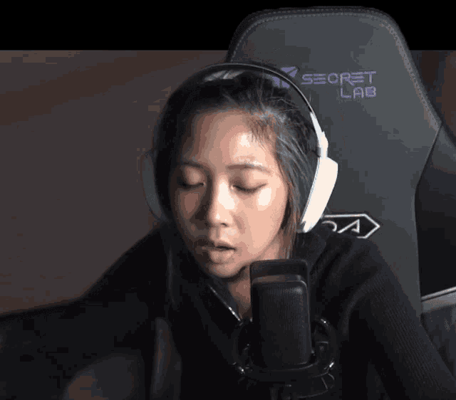 a woman wearing headphones sitting in a secret lab chair