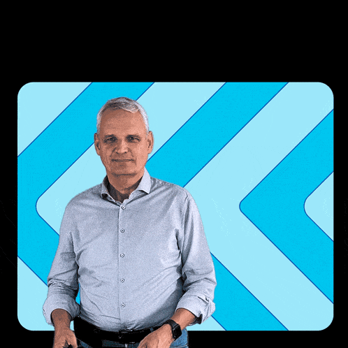 a man in a blue shirt is standing in front of a blue striped background