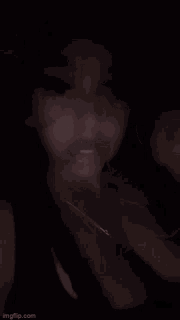 a blurry picture of a woman 's face in the dark with a necklace around her neck .