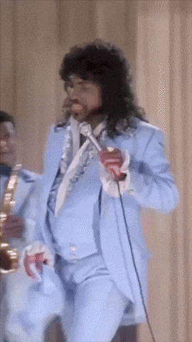 a man in a blue suit singing into a microphone