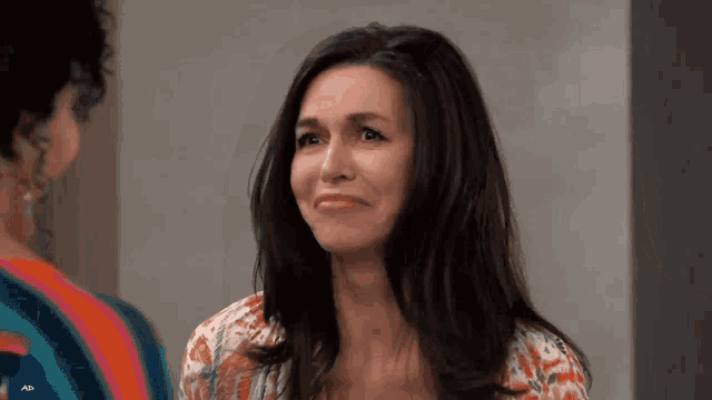 a woman is making a funny face while standing next to another woman .