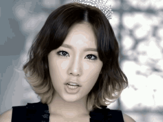 a woman with a tiara on her head is making a face