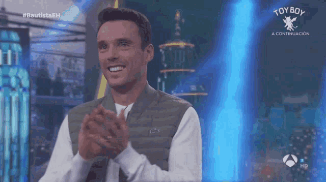 a man is clapping in front of a toy boy logo