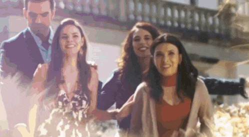 a group of people are standing next to each other and smiling .