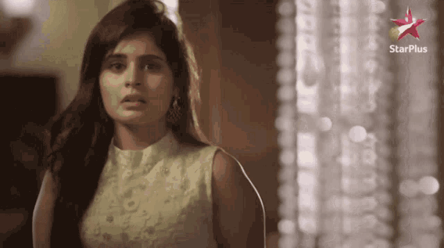 a woman is standing in front of a starplus logo