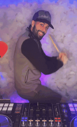 a man playing drums in front of a mixer that says pioneer