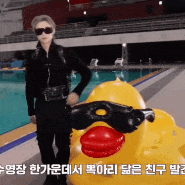 a man standing next to a rubber duck with a mask on it