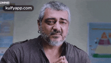 a man with a beard and earrings is making a face .