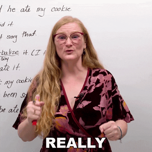 a woman giving a thumbs up in front of a whiteboard that says " really "