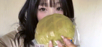 a woman is blowing a bubble with a balloon in front of her face .