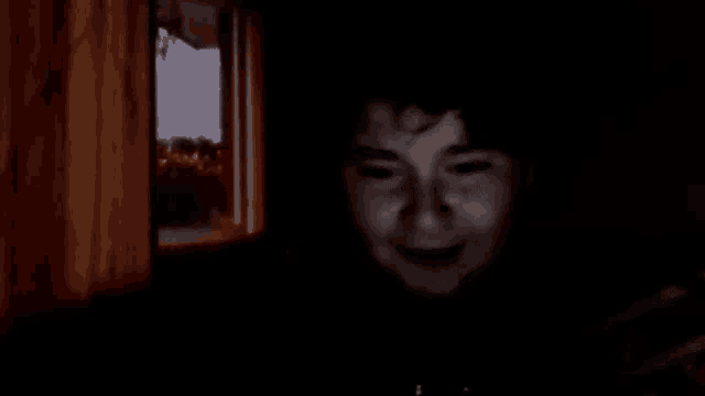 a close up of a child 's face in a dark room .