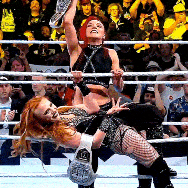 a woman in a wrestling ring is wearing a belt that says ' smack down ' on it