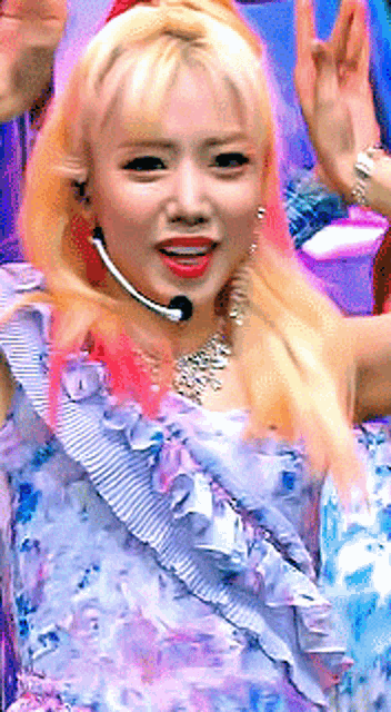 a close up of a woman wearing a purple dress and a microphone