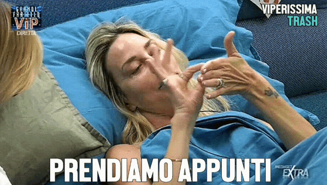 a woman laying in a bed with the words prendiamo appunti written on the bottom