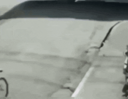 a man is riding a bike down a street while another man is riding a motorcycle .