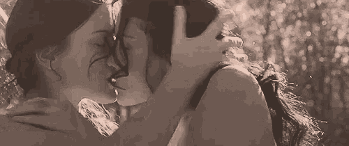a couple of women are kissing each other in a black and white photo