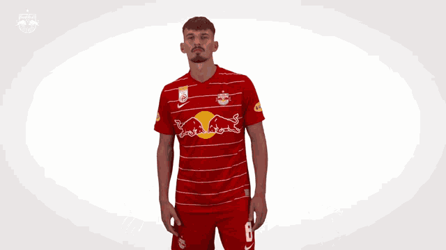 a man wearing a red and white striped jersey with a red bull on it
