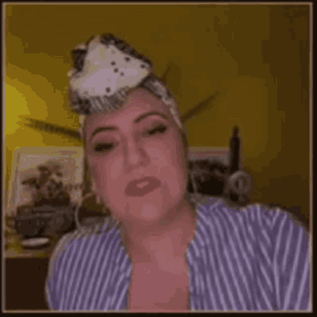 a woman wearing a striped shirt and a bandana on her head .
