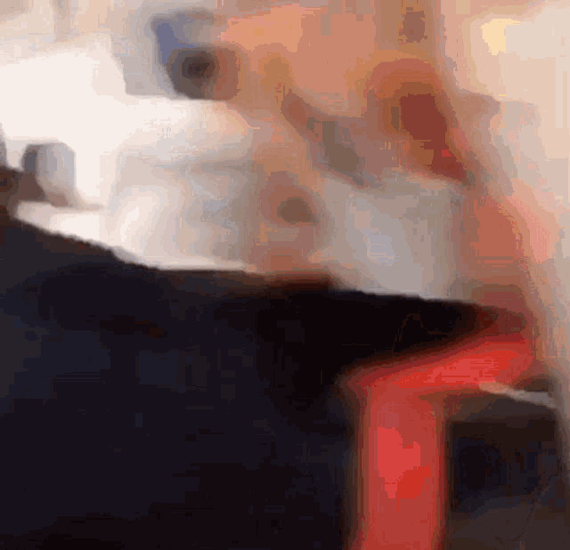 a blurry picture of a person sitting on a chair with a red ribbon around their waist