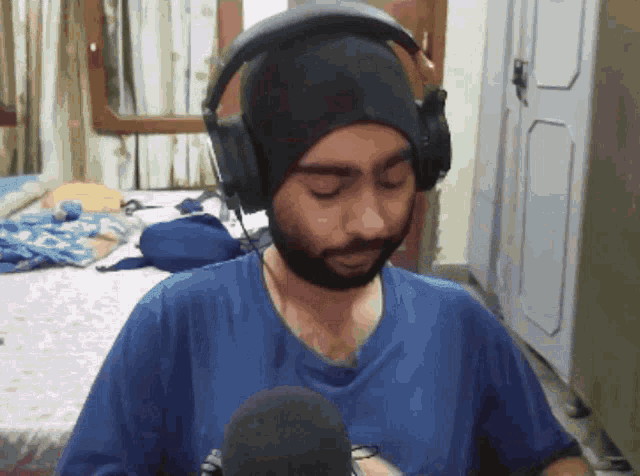 a man wearing headphones and a beanie looks at the camera