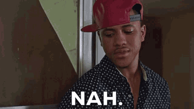 a man wearing a red hat has the word nah written on his chest