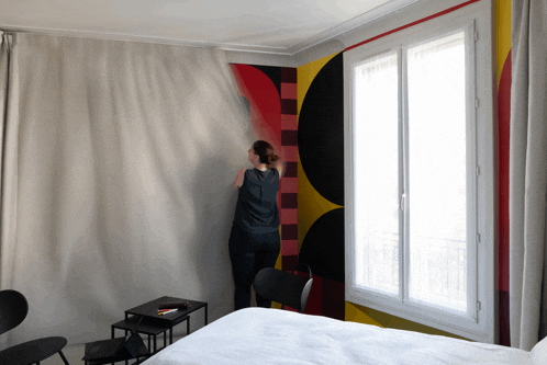 a woman looks out a window in a room