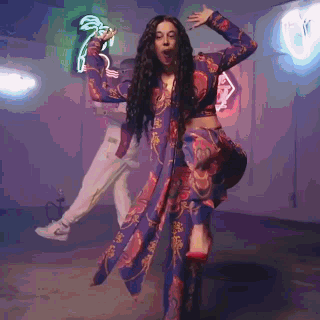 a woman with long hair is singing into a microphone in a room