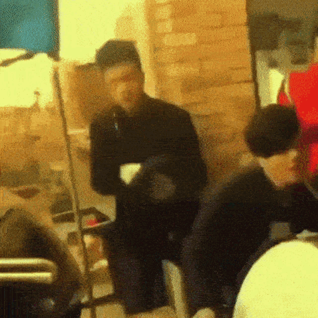 a blurry picture of a man sitting in a chair holding a cup of coffee