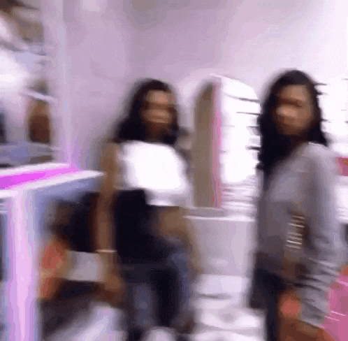 a blurry picture of two women standing next to each other in a store .