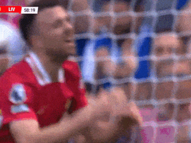 a blurred image of a man in a red shirt with the word liv on the bottom