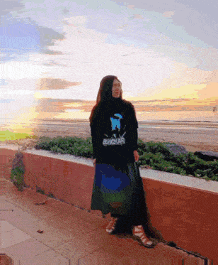 a woman wearing a black hoodie that says bangkaar