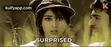 a man and a woman are standing next to each other and the woman is wearing a hat and looking surprised .