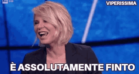 a woman in a black suit is laughing with the words e assolutamente finito behind her