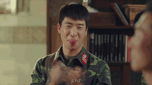 a man in a military uniform is clapping his hands and has the word syiz on the bottom