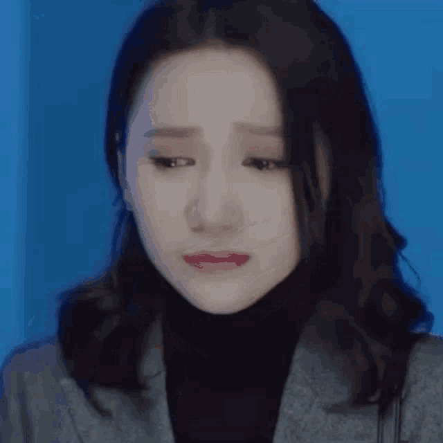 a close up of a woman 's face with a tear running down her cheek .